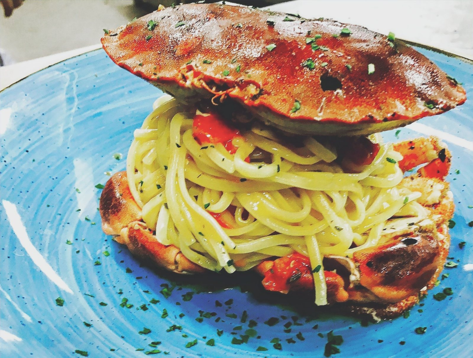 Spaghetti al granchio serviti nel piatto azzurro